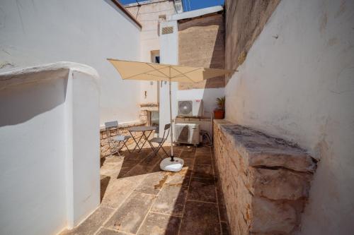 a patio with an umbrella in the corner of a building at La Pupa coi baffi - Edificio Storico in Centro in Conversano
