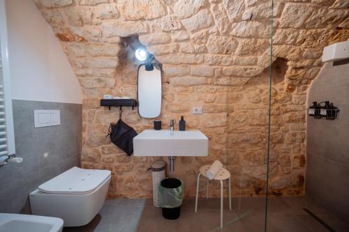 a bathroom with a sink and a stone wall at La Pupa coi baffi - Edificio Storico in Centro in Conversano