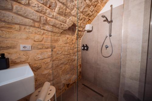 a bathroom with a walk in shower and a sink at La Pupa coi baffi - Edificio Storico in Centro in Conversano