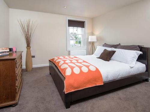 a bedroom with a bed and a dresser and a window at Willow in Gatehouse of Fleet