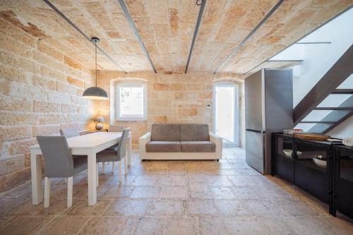 a kitchen and dining room with a brick wall at La Pupa coi baffi - Edificio Storico in Centro in Conversano