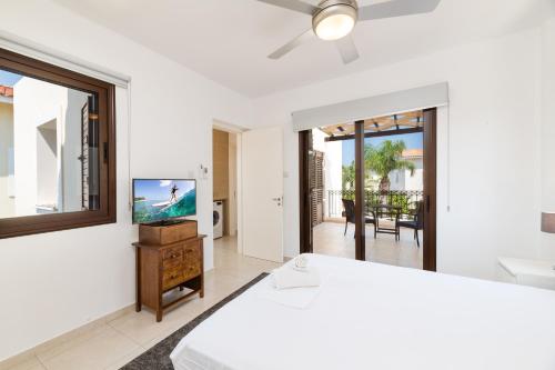 een slaapkamer met een bed en een flatscreen-tv bij Villa Enaria Serene 3Bdr Retreat in Ayia Thekla in Ayia Napa