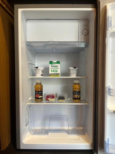 an open refrigerator with food items in it at Romantic Swiss Cabin Hideaway & Hot Tub Spa Pool in Chandlers Ford