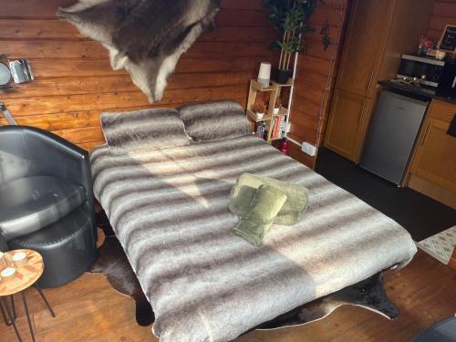 a bed in the middle of a living room at Romantic Swiss Cabin Hideaway & Hot Tub Spa Pool in Chandlers Ford