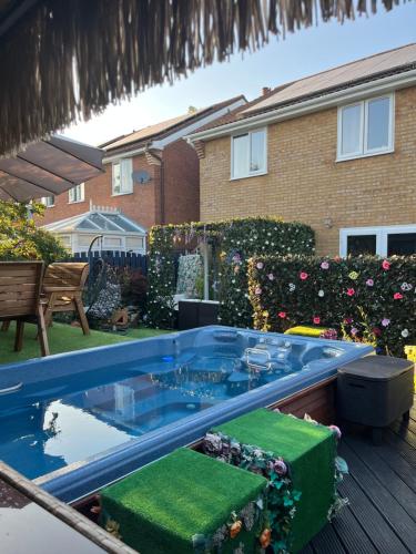 a hot tub in the backyard of a house at Romantic Swiss Cabin Hideaway & Hot Tub Spa Pool in Chandlers Ford