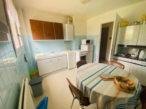 une petite cuisine avec une table et un panier dans l'établissement Charmant F1, 2 couchages à Amélie-les-Bains, proche thermes et centre, animaux acceptés - FR-1-703-128, à Amélie-les-Bains-Palalda