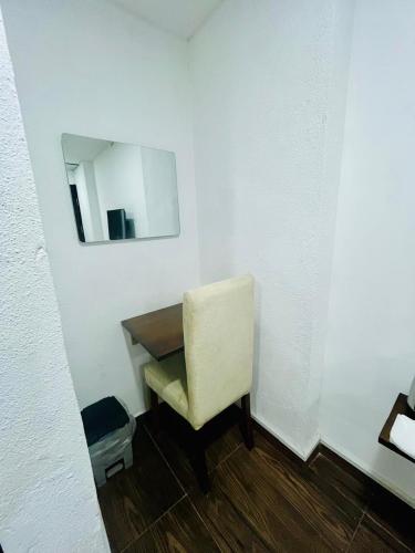 a white room with a chair and a mirror at Newyork Guest House and Restaurant Colombo 05 in Colombo