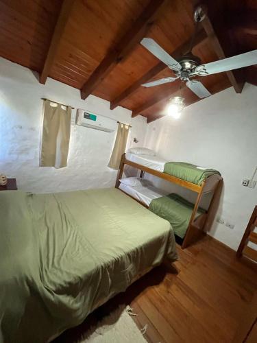 Un dormitorio con dos literas y un ventilador de techo. en Las cabañas de Pascu, en Santa Rosa de Calamuchita
