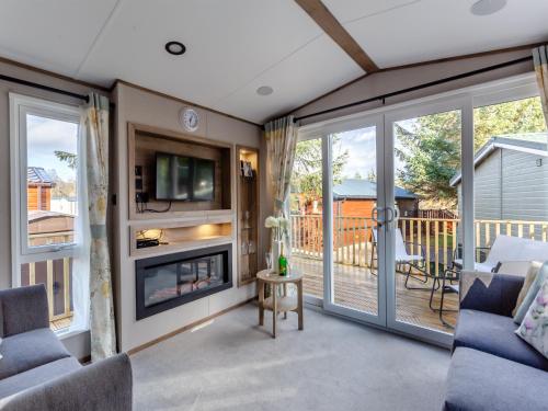 a living room with a fireplace and a tv at The Pines in Aviemore