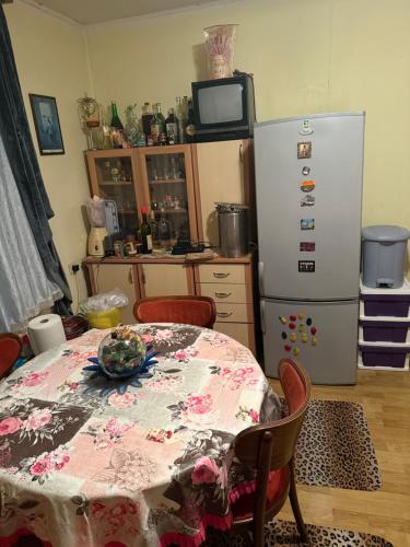 a kitchen with a table and a refrigerator at Apartman Ex-Yu in Španjola