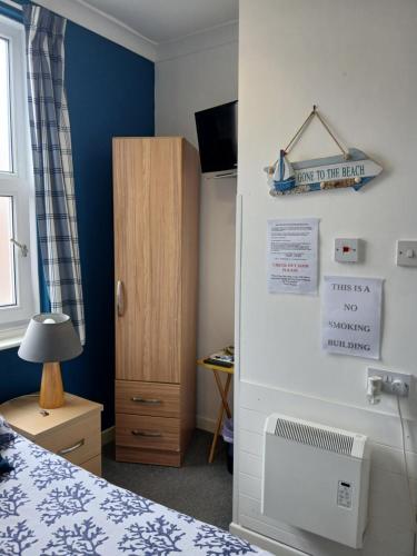 a bedroom with a bed and a heater on the wall at Rowntree Seaview Holiday Flats small double room with no view in Bridlington