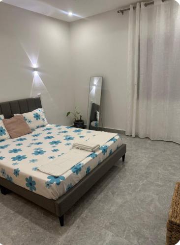 a bedroom with a bed with blue flowers on it at Chambre Cosy à Dakar in Dakar