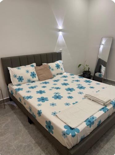 a bed with blue flowers on it in a bedroom at Chambre Cosy à Dakar in Dakar