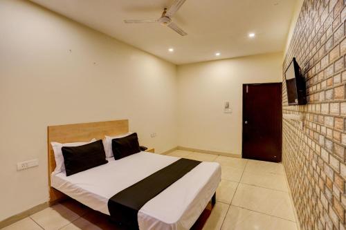 a bedroom with a bed and a wall with a tv at Hotel O Blue Vibes in Meerut