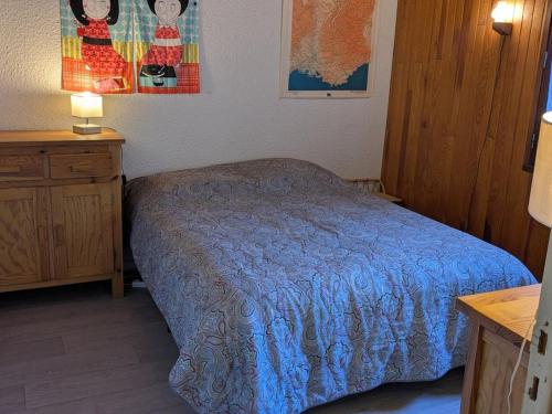 a bedroom with a bed with a blue comforter at Charmant T2 5 pers, Sud, balcon, TV, lave-linge, garage optionnel, calme à Orcières - FR-1-262-187 in Orcières