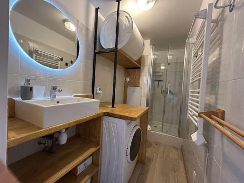une salle de bain avec un lavabo et une machine à laver dans l'établissement Charmant 2P avec terrasse Sud, proche pistes - Montgenèvre - FR-1-330D-138, à Montgenèvre
