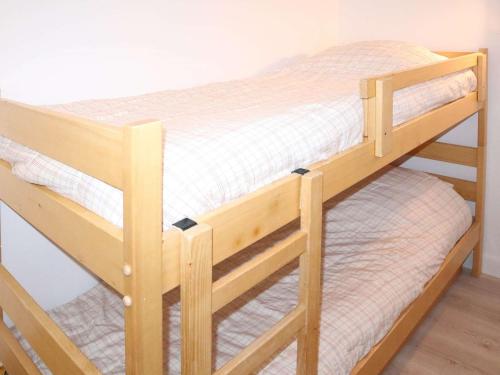 - un lit superposé en bois avec des draps blancs dans l'établissement Appartement Duplex pour 12 pers, aux pieds des pistes avec gardien - FR-1-322-573, aux Orres