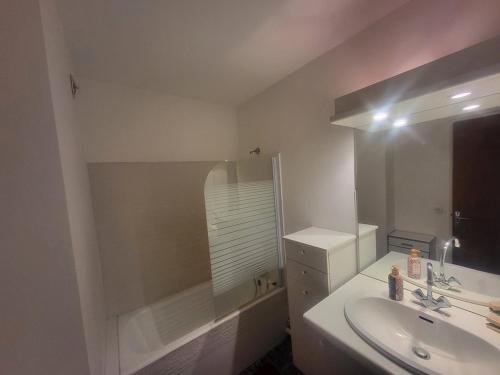 une salle de bain blanche avec un lavabo et un miroir dans l'établissement Duplex 65m² face aux pistes, balcon plein sud, 2 chambres, tout équipé, ascenseur - FR-1-266-157, à Montgenèvre