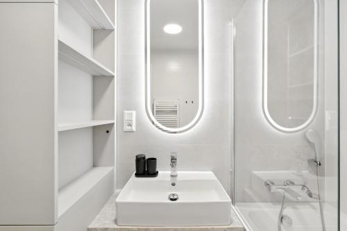 a white bathroom with a sink and a mirror at Castle-side Luxury Residence on Danube River bank,Free Parking in Bratislava