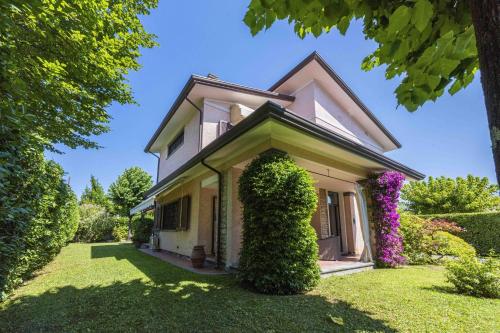a white house with a green yard at Villa Federica by MMega in Forte dei Marmi