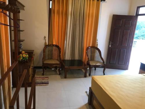 a bedroom with a bed and two chairs and a table at Villa WG15 in Narandanda