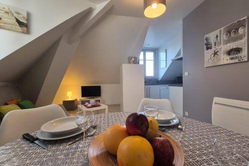 une table de salle à manger avec un bol de fruits dessus dans l'établissement Appartement bord de plage avec piscine, à Les Sables-dʼOlonne