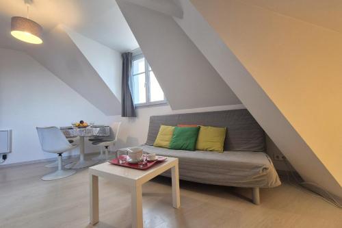 un salon avec un canapé et une table dans l'établissement Appartement bord de plage avec piscine, à Les Sables-dʼOlonne