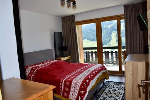 a bedroom with a bed and a balcony with a view at Morzine T2 vue imprenable in Morzine