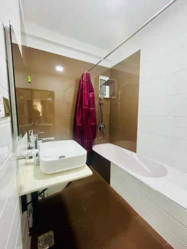a bathroom with a sink and a bath tub at Newyork Guest House and Restaurant Colombo 05 in Colombo