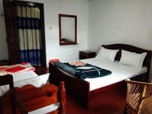a bedroom with a bed and a mirror and a chair at Green Villa in Nuwara Eliya