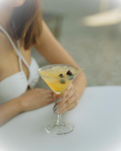 a woman is holding a cocktail in a glass at Ramitos Hotel in Turunc