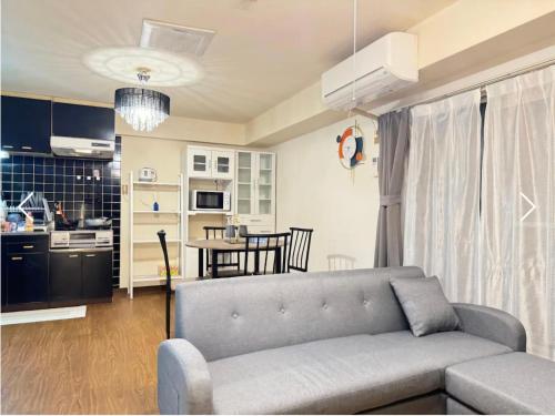 Una sala de estar con un sofá y una cocina. en r311 Spacious Apartment near Dotonbori Namba Walk to Nipponbashi, en Osaka