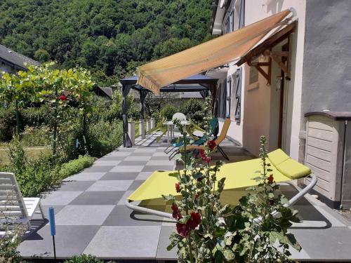 une terrasse avec une table et des chaises dans une maison dans l'établissement la maison blanche, à Ustou