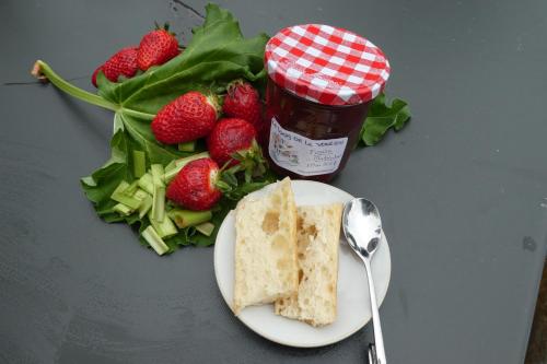 ein Teller mit Essen mit Salat und Marmelade neben Erdbeeren in der Unterkunft Le Logis de la Voulzie in Provins