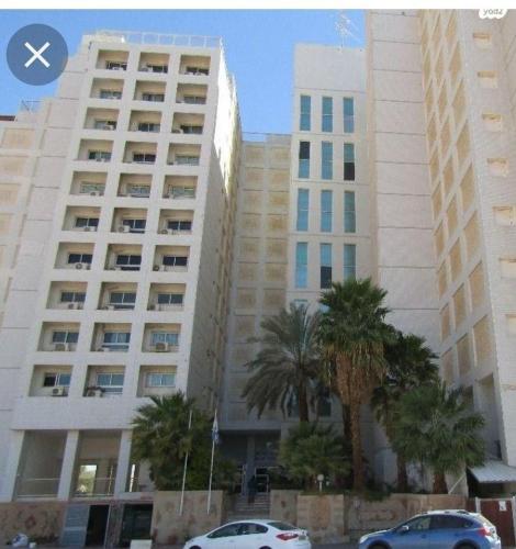 two tall buildings with palm trees in front of them at אלונים 25 in Eilat