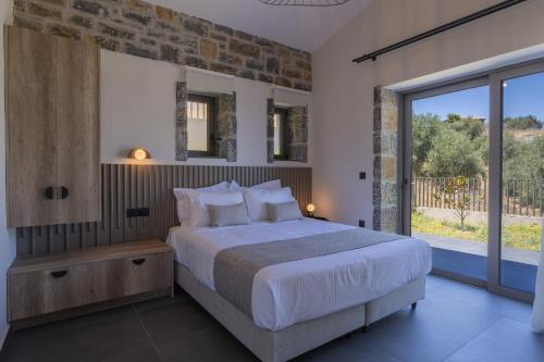 a bedroom with a large bed and a large window at Valley View Villas - With 3 Pools in Agia Triada