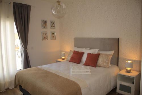 a bedroom with a large bed with two lamps on it at Vila Prata Dourada in Ferreira do Zêzere