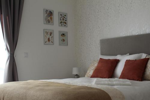 a bedroom with a bed with orange pillows and a window at Vila Prata Dourada in Ferreira do Zêzere