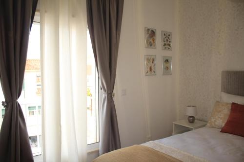a bedroom with a bed and a large window at Vila Prata Dourada in Ferreira do Zêzere