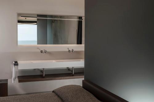 a bathroom with a sink and a mirror at Hotel Commodore in Cervia