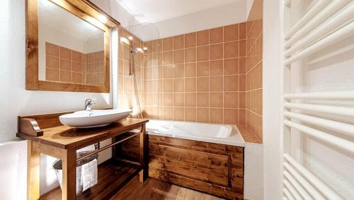 a bathroom with a sink and a bath tub at Appartement familial Abries - Jacuzzi et piscine - Pied des pistes in Abriès