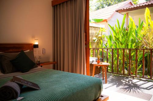 a bedroom with a bed and a balcony at Twiny's in Kuta Lombok