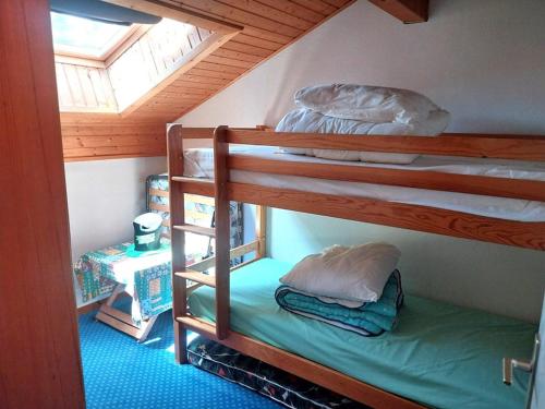deux lits superposés dans une chambre avec fenêtre dans l'établissement Appartement au calme avec balcon et kitchenette - 3 pièces - FR-1-573-41, à Bonnevaux