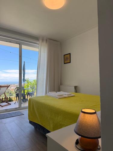 a bedroom with a green bed and a balcony at Alfazema Sunset House in Vila Nova de Gaia