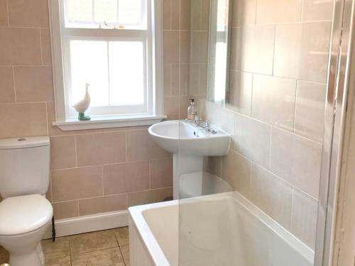 a bathroom with a sink and a tub and a toilet at Neuk Hoose in Crail