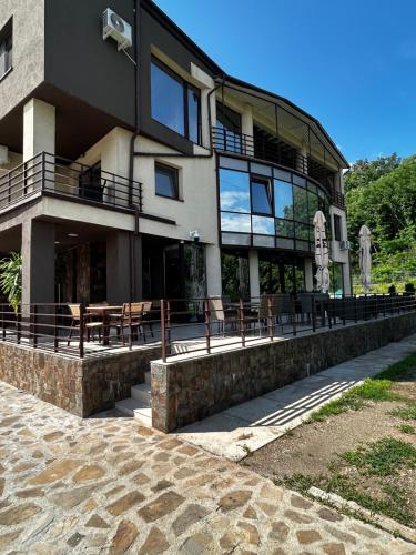 a building with tables and chairs in front of it at Vila Premiere Bistro-Spa in Piatra Neamţ