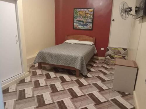 a bedroom with a bed and a tiled floor at kamelos Hospedaje in Paita