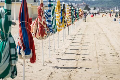 a row of closed umbrellas on the beach at Les 2 Villas in Trouville-sur-Mer