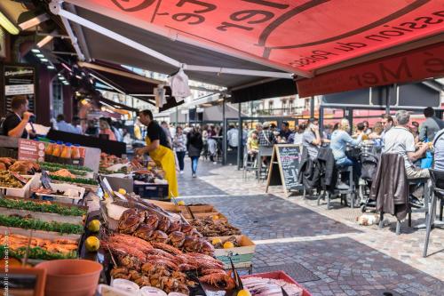 a market with lots of food and people sitting at tables at Les 2 Villas in Trouville-sur-Mer