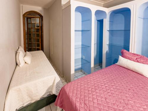 two beds in a room with blue and white at Casa Araçás in Vila Velha
